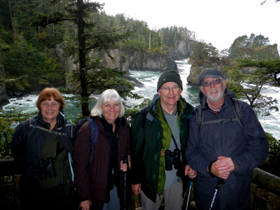 Four participants at Cape Flattery with the rocky Olympic Peninsula shoreline in the background