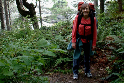 Backpacker surrounded by ferns on a headland trail on the Olympic Coast 