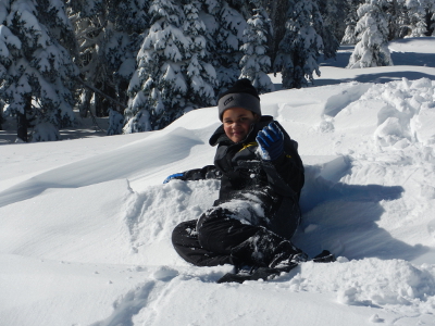 A child plays in snow while on an Olympic National Park snowshoe with his family at Hurricane Ridge