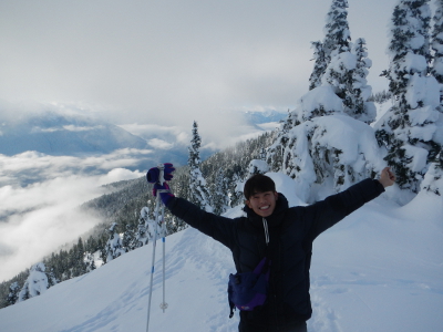 A jubilant participant on a Hurricane Ridge snowshoe tour puts his hangs up in the air on a particularly sunny day with snow-laden trees in the background