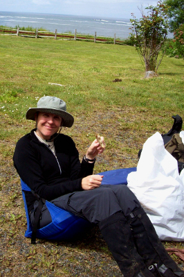 Hiker seated in a packable chair with a nylon hat, wood shirt, nylon hiking pants, and gaiters